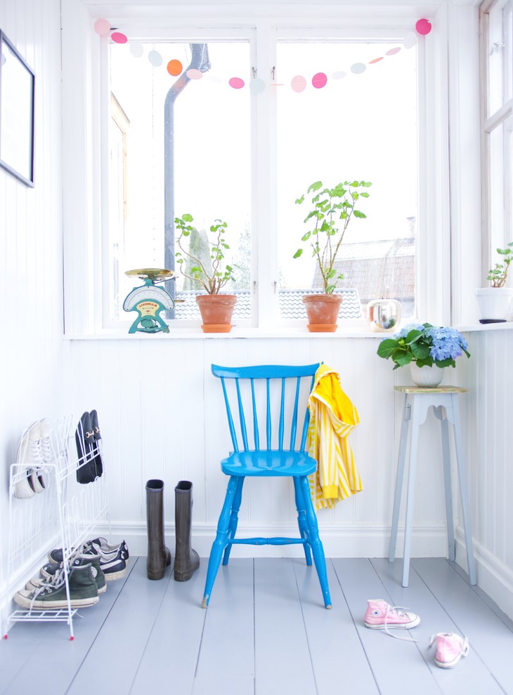 Photo of a small scandinavian mudroom in Other with white walls and painted wood floors.