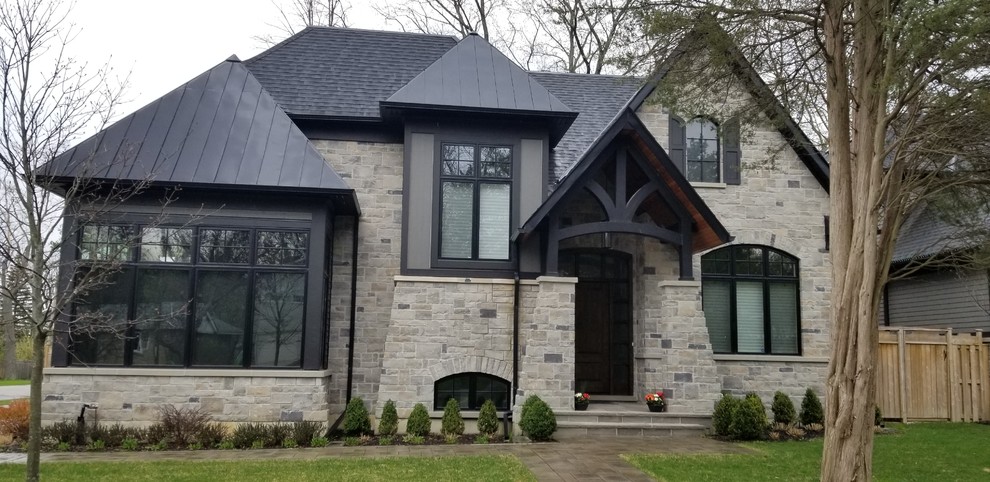 Inspiration for an expansive transitional two-storey grey house exterior in Toronto with stone veneer, a gable roof and a mixed roof.