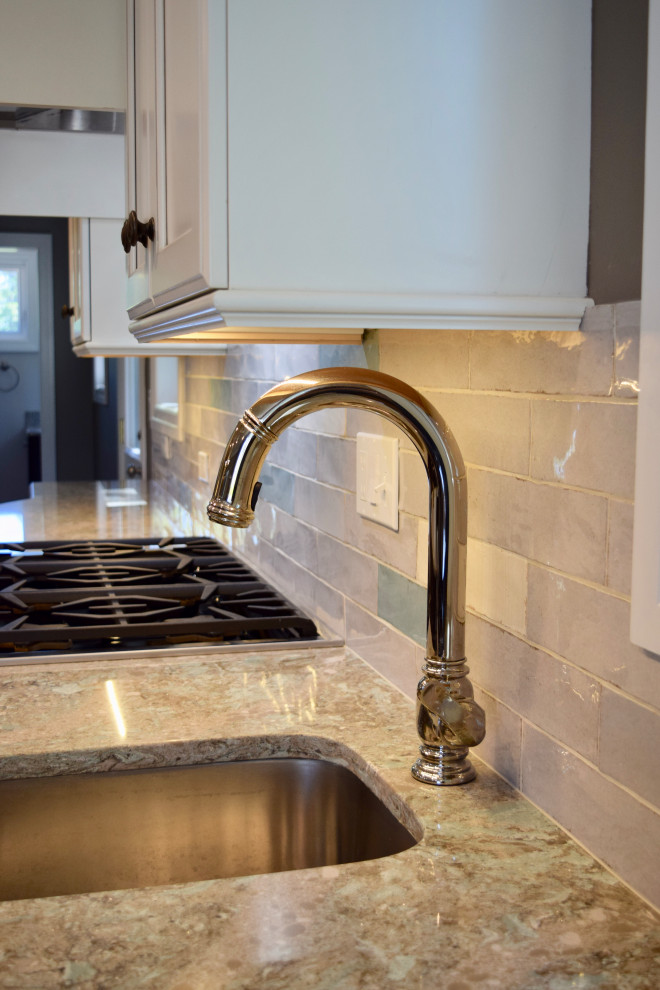Eat-in kitchen - huge transitional vinyl floor and brown floor eat-in kitchen idea with a farmhouse sink, recessed-panel cabinets, white cabinets, quartz countertops, multicolored backsplash, ceramic backsplash, stainless steel appliances, an island and multicolored countertops