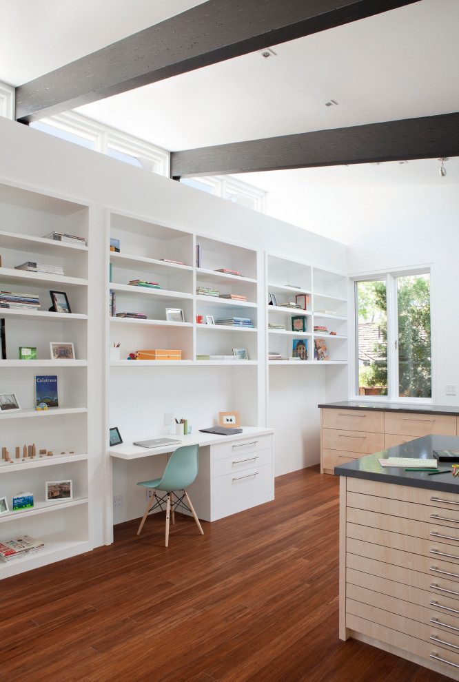 Immagine di una stanza da lavoro minimal con pareti bianche, pavimento in legno massello medio, nessun camino, scrivania incassata e pavimento marrone