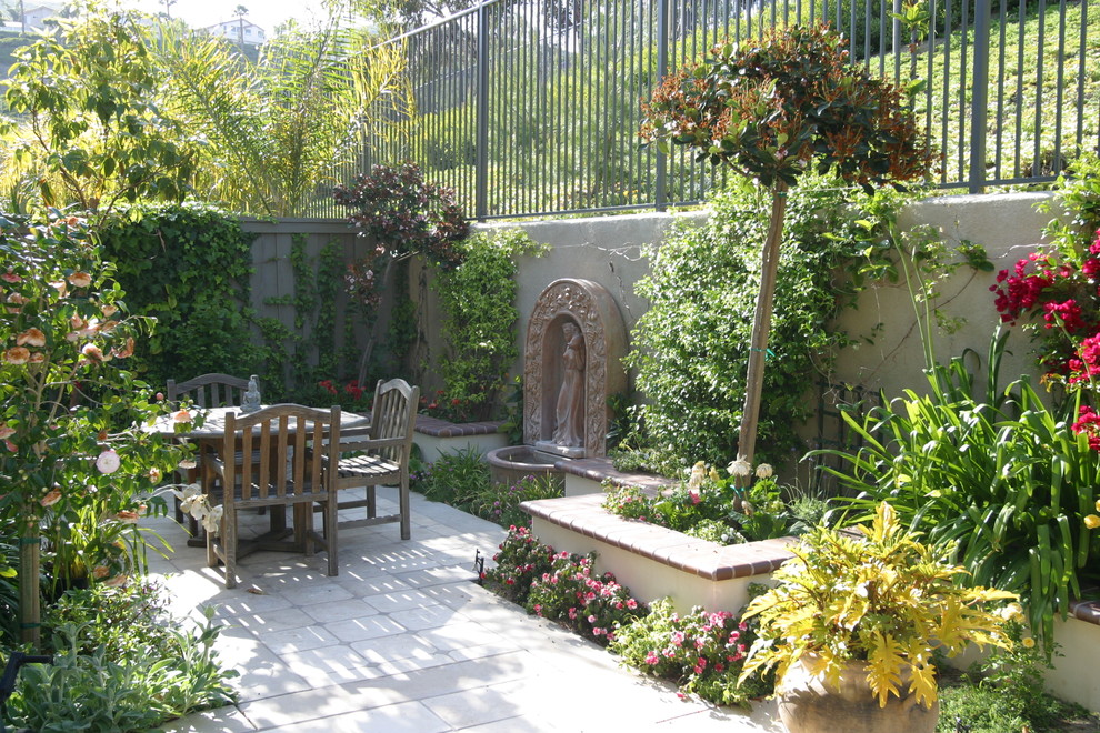This is an example of a mediterranean courtyard garden in Orange County with a water feature.