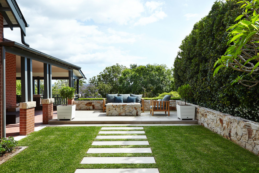 This is an example of a traditional backyard patio in Sydney with concrete pavers and no cover.