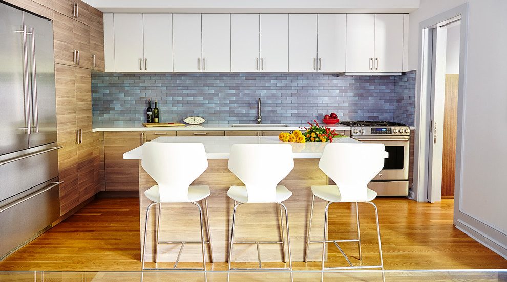 Photo of a mid-sized contemporary l-shaped kitchen in New York with an undermount sink, flat-panel cabinets, quartz benchtops, blue splashback, ceramic splashback, stainless steel appliances, with island, white cabinets and medium hardwood floors.