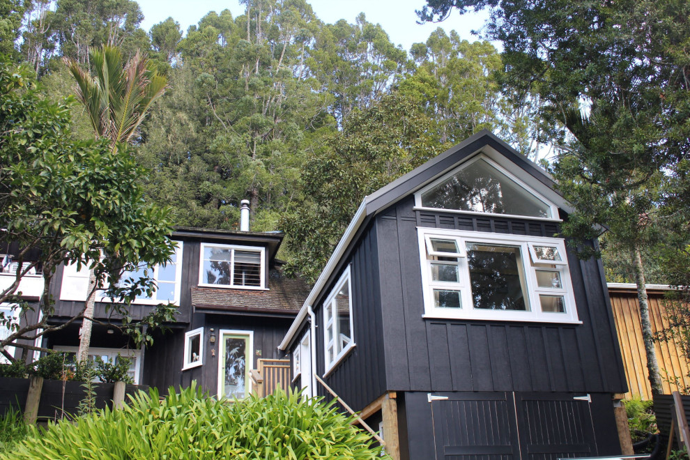 Kleines, Zweistöckiges Rustikales Haus mit schwarzer Fassadenfarbe, Satteldach, Blechdach und schwarzem Dach in Sonstige