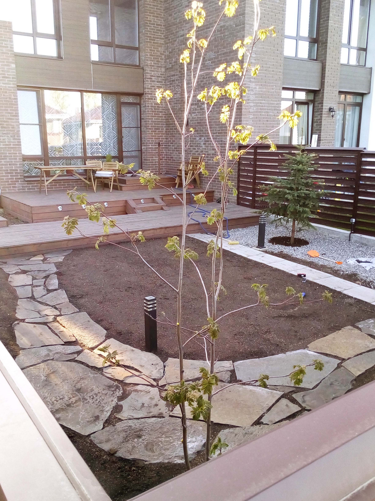 Работы по реализации проекта: выполнена терраса, мощение, начало посадки растени