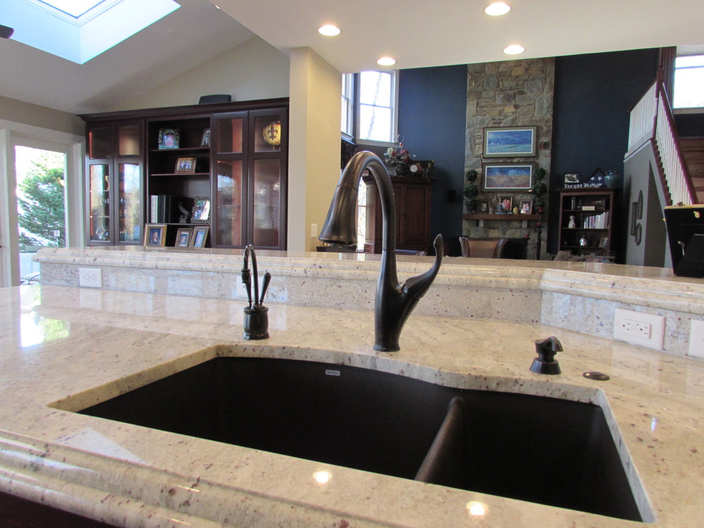 Inspiration for a large transitional l-shaped medium tone wood floor eat-in kitchen remodel in DC Metro with an undermount sink, dark wood cabinets, granite countertops, stainless steel appliances and an island