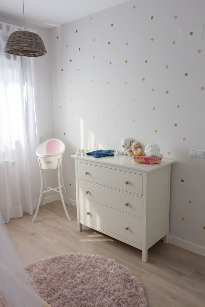 Photo of a small scandinavian kids' room for girls in Madrid with grey walls, light hardwood floors and beige floor.