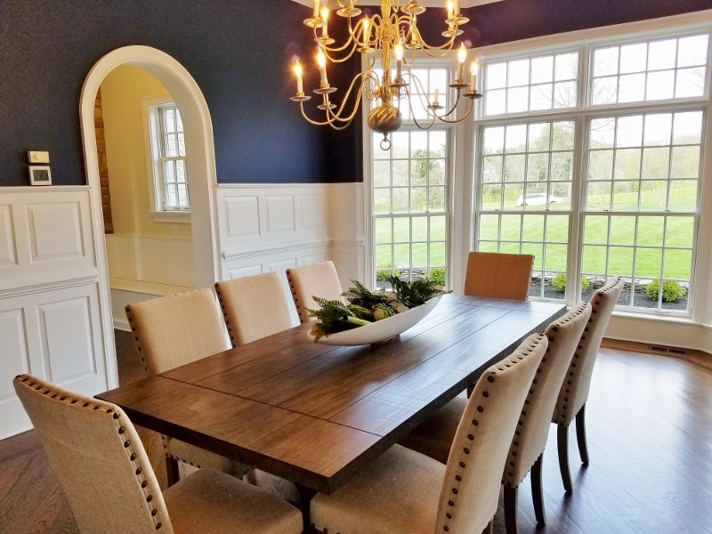 This is an example of a large transitional dining room in Philadelphia with blue walls, dark hardwood floors and no fireplace.