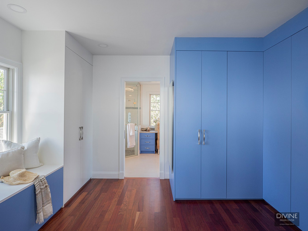 Источник вдохновения для домашнего уюта: огромная гардеробная комната в стиле неоклассика (современная классика) с стеклянными фасадами, синими фасадами, паркетным полом среднего тона и коричневым полом