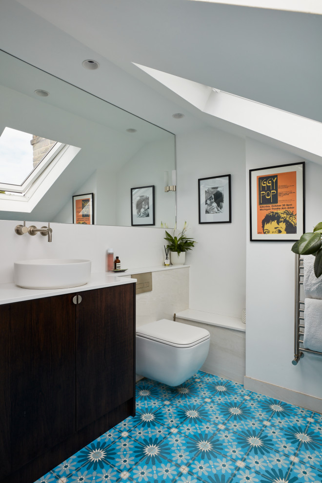 Small transitional master bathroom in London with flat-panel cabinets, dark wood cabinets, a curbless shower, a wall-mount toilet, beige tile, porcelain tile, beige walls, cement tiles, a wall-mount sink, engineered quartz benchtops, blue floor, a hinged shower door, white benchtops, a niche, a single vanity and a floating vanity.