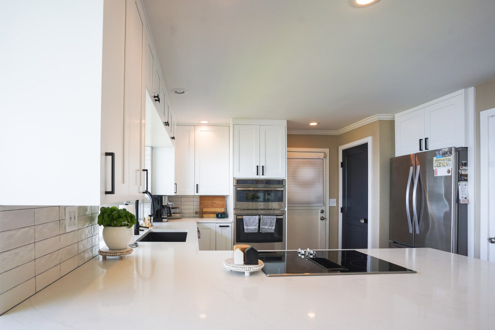 Inspiration for a small modern u-shaped eat-in kitchen in Seattle with an undermount sink, white cabinets, granite benchtops, white splashback, ceramic splashback, stainless steel appliances, with island and white benchtop.