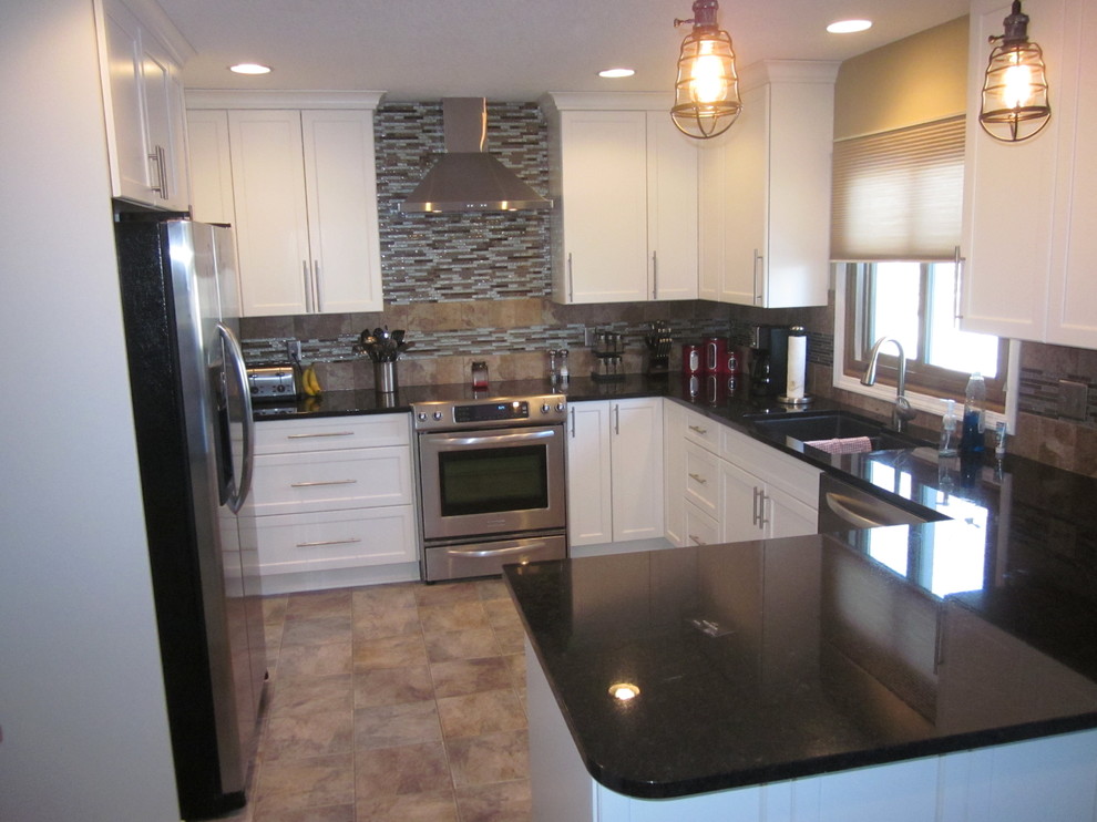 Large transitional u-shaped ceramic tile enclosed kitchen photo with a double-bowl sink, shaker cabinets, white cabinets, solid surface countertops, multicolored backsplash, stone tile backsplash, stainless steel appliances and a peninsula