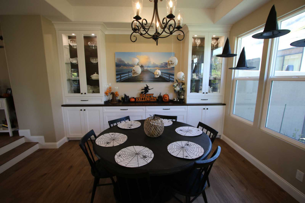 This is an example of a large transitional dining room in Orange County with light hardwood floors, brown floor and vaulted.