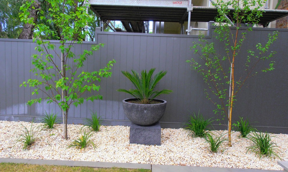 Mid-sized contemporary front yard partial sun garden in Geelong with gravel.