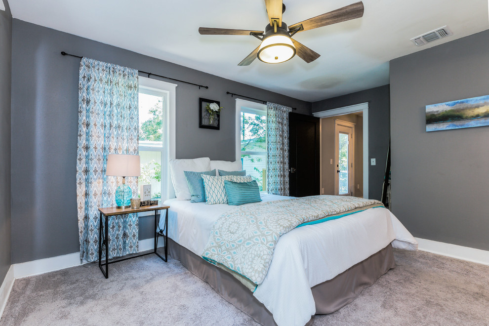 This is an example of a large country master bedroom in Austin with grey walls and carpet.