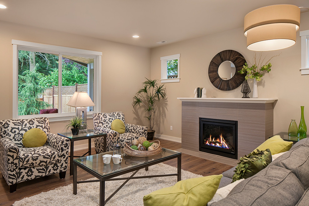 Photo of an arts and crafts open concept living room in Seattle with beige walls, medium hardwood floors, a standard fireplace, a tile fireplace surround and a wall-mounted tv.