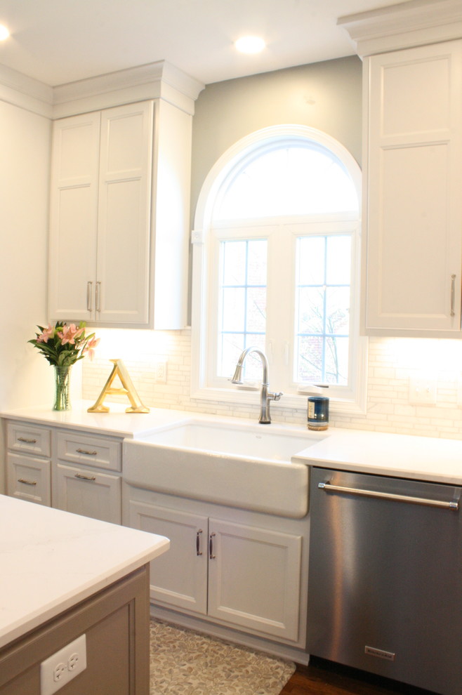 Transitional dark wood floor and brown floor kitchen photo in Nashville with a farmhouse sink, flat-panel cabinets, white cabinets, white backsplash, stainless steel appliances, an island and white countertops