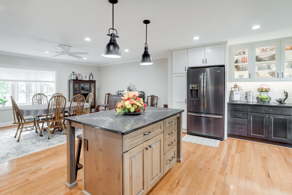 Inspiration for a large transitional u-shaped kitchen remodel in Baltimore with recessed-panel cabinets, quartz countertops, black appliances and an island