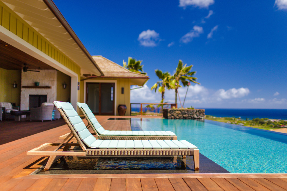 Inspiration for a tropical backyard rectangular infinity pool in Hawaii with decking.
