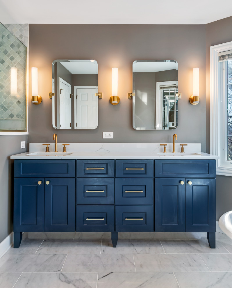 Inspiration for a large traditional master bathroom in Chicago with flat-panel cabinets, blue cabinets, a claw-foot tub, an open shower, a one-piece toilet, white tile, marble, grey walls, marble floors, a drop-in sink, engineered quartz benchtops, white floor, a hinged shower door, white benchtops, a niche, a double vanity and a freestanding vanity.