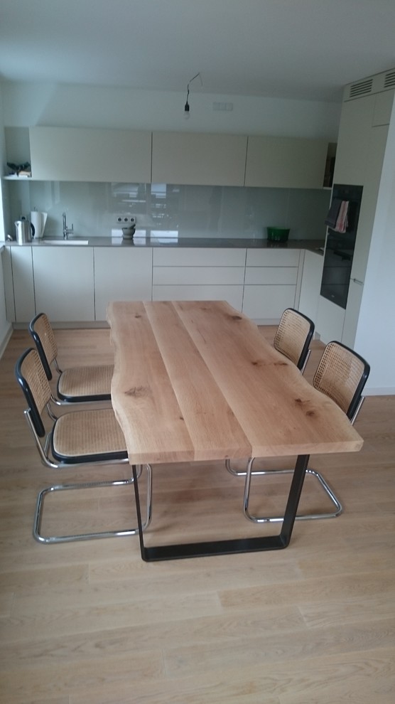 Große Moderne Wohnküche ohne Kamin mit weißer Wandfarbe, hellem Holzboden und beigem Boden in München