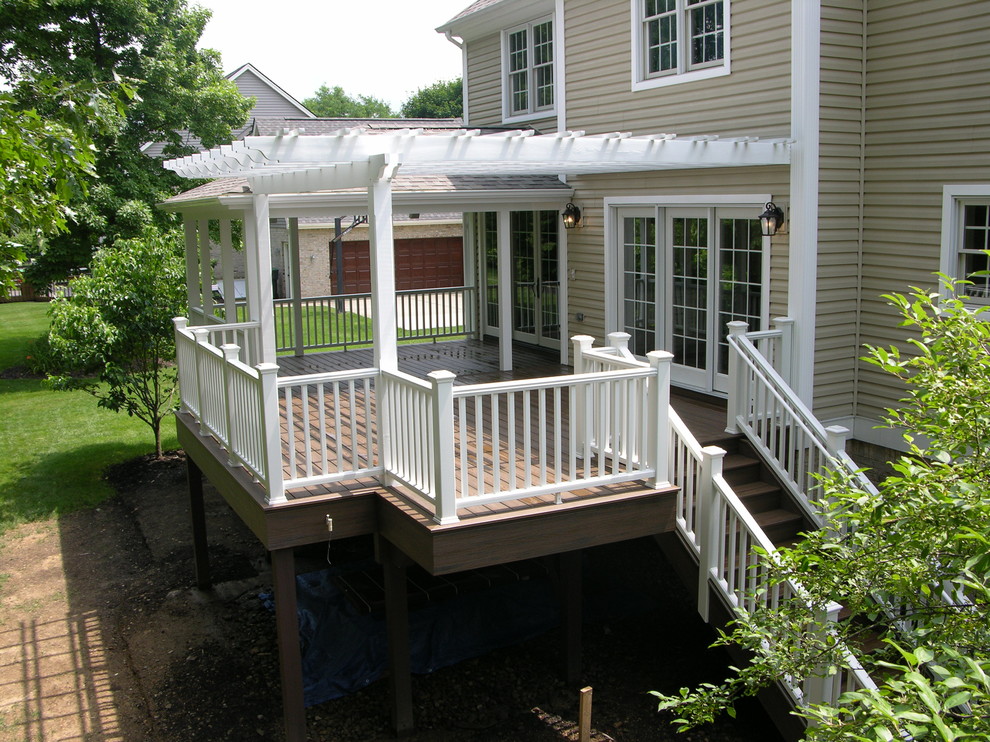 Large traditional backyard deck in Other with a pergola.