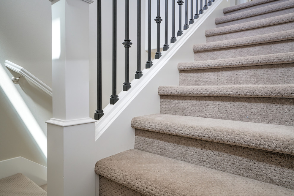 This is an example of a transitional carpeted u-shaped staircase in Portland with carpet risers and mixed railing.
