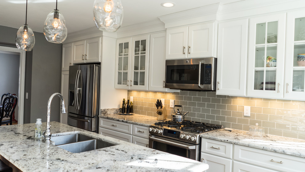 Inspiration for a mid-sized traditional l-shaped separate kitchen in Milwaukee with flat-panel cabinets, white cabinets, granite benchtops, grey splashback, stainless steel appliances and with island.