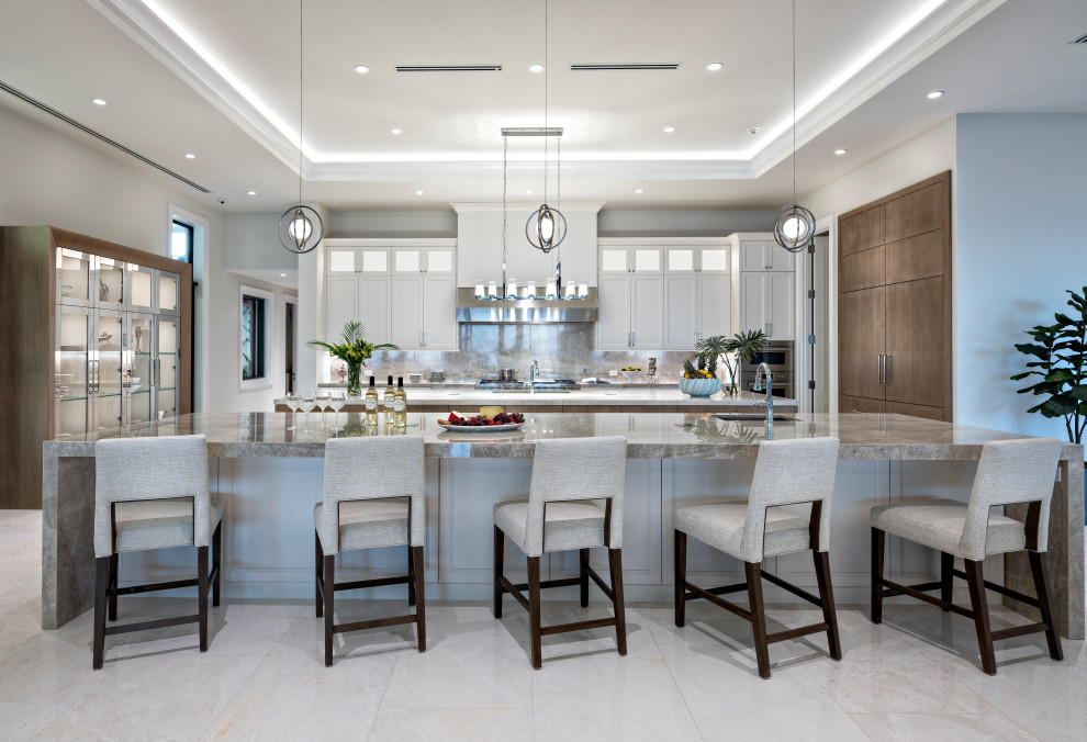 Design ideas for a large beach style open plan kitchen in Miami with a drop-in sink, shaker cabinets, white cabinets, granite benchtops, grey splashback, granite splashback, stainless steel appliances, marble floors, with island, grey floor, grey benchtop and recessed.