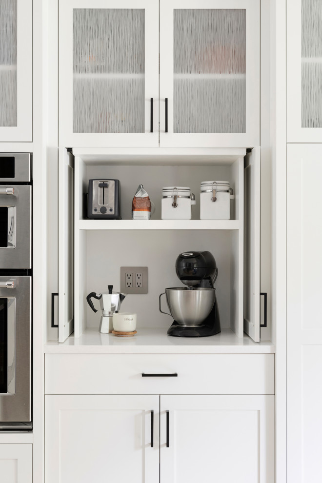 Foto de cocinas en L clásica renovada con puertas de armario blancas, salpicadero verde y encimeras blancas