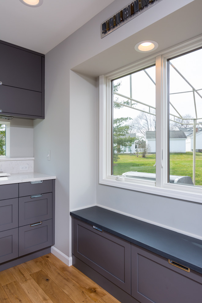 Example of a mid-sized trendy single-wall light wood floor and brown floor eat-in kitchen design in Detroit with an undermount sink, flat-panel cabinets, gray cabinets, quartz countertops, white backsplash, stone slab backsplash, stainless steel appliances and an island
