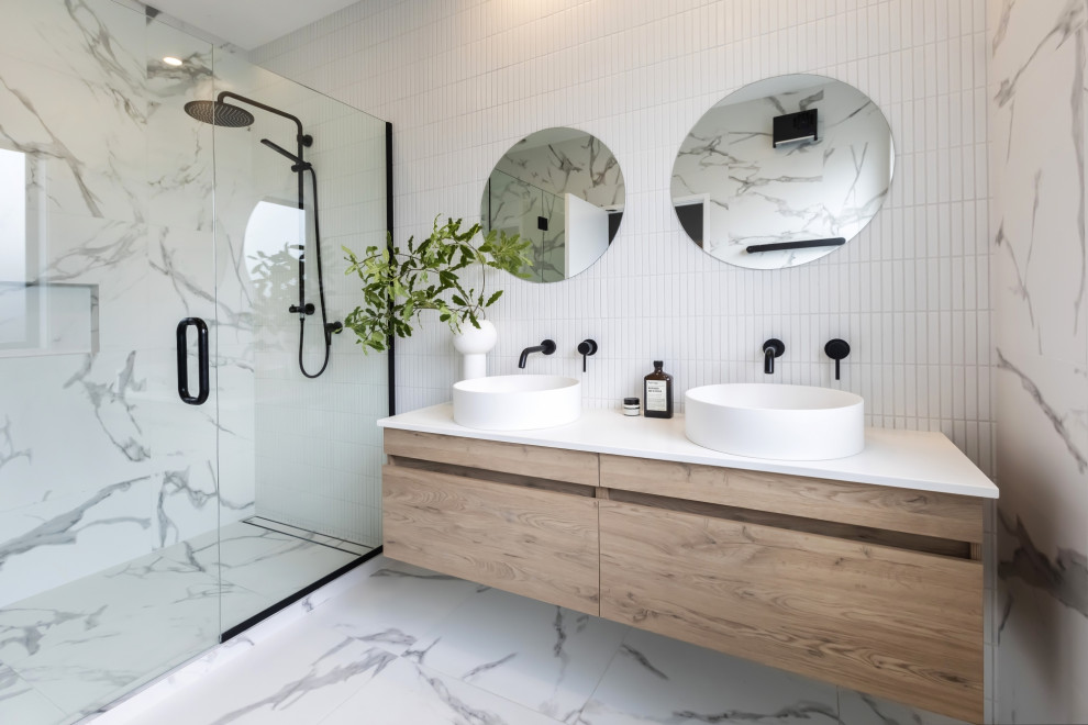 This is an example of a mid-sized contemporary master bathroom in Christchurch with beige cabinets, an open shower, white tile, ceramic tile, white walls, cement tiles, a vessel sink, engineered quartz benchtops, grey floor, a hinged shower door, white benchtops, a double vanity and a floating vanity.