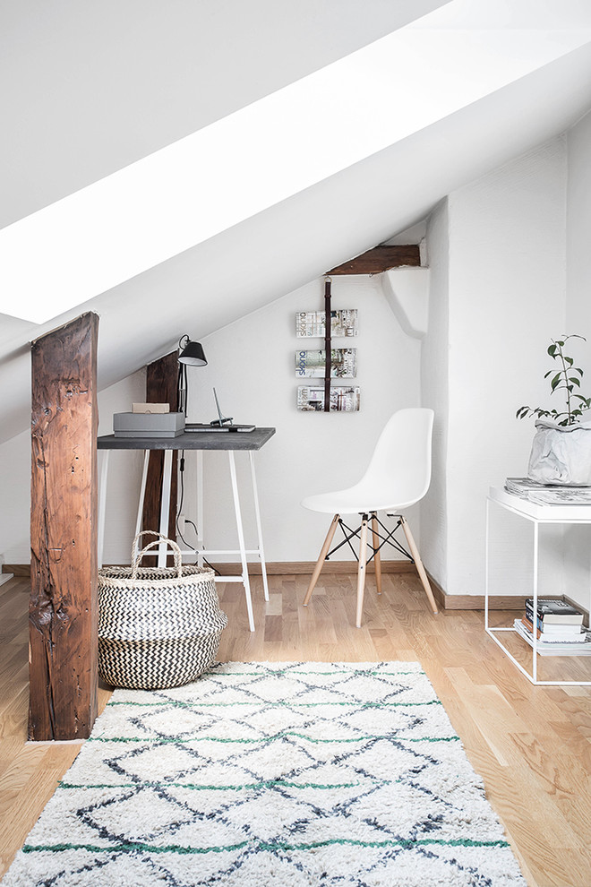 Inspiration for a small scandinavian home studio in Gothenburg with white walls, light hardwood floors, no fireplace and a freestanding desk.