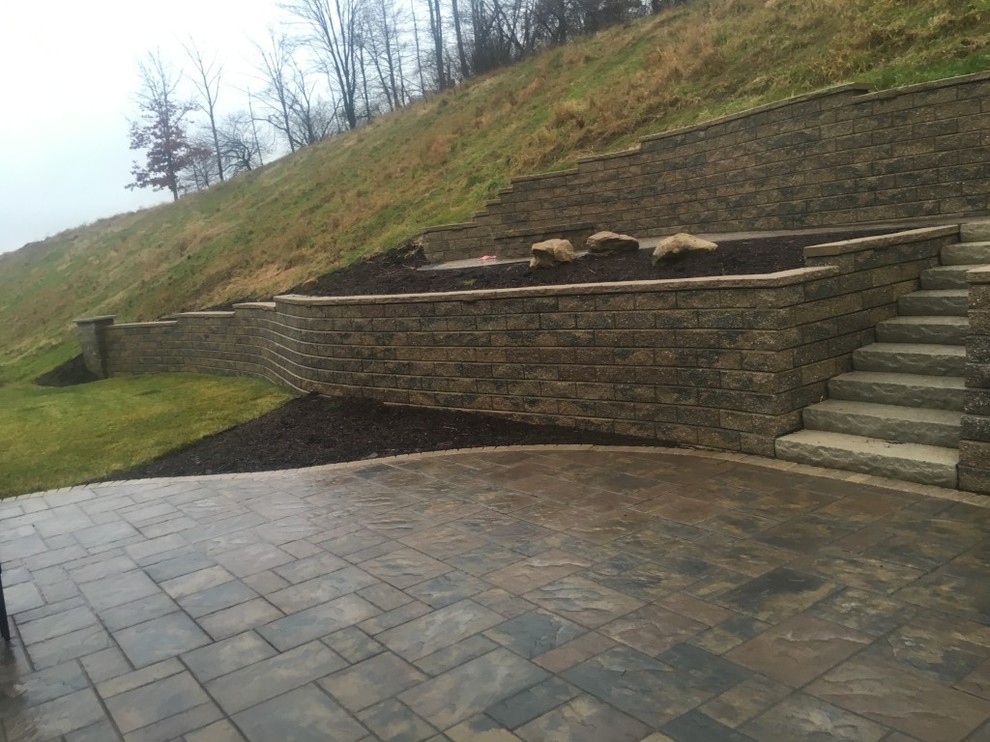 This is an example of a mid-sized transitional backyard full sun garden in Other with natural stone pavers.