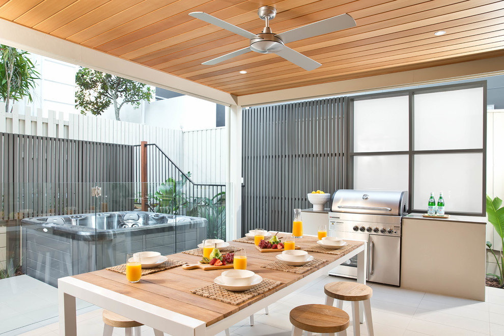 Mid-sized contemporary courtyard patio in Sunshine Coast with an outdoor kitchen, brick pavers and a roof extension.