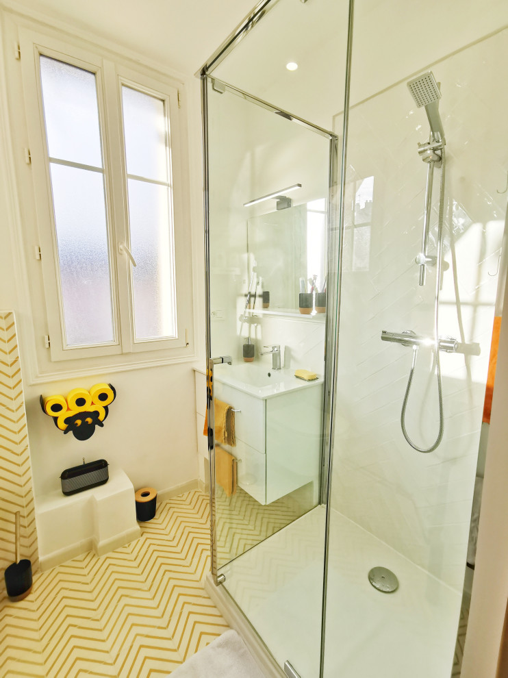 Inredning av ett modernt litet vit vitt badrum med dusch, med släta luckor, vita skåp, en dubbeldusch, en vägghängd toalettstol, vit kakel, keramikplattor, vita väggar, cementgolv, ett undermonterad handfat, gult golv och dusch med gångjärnsdörr