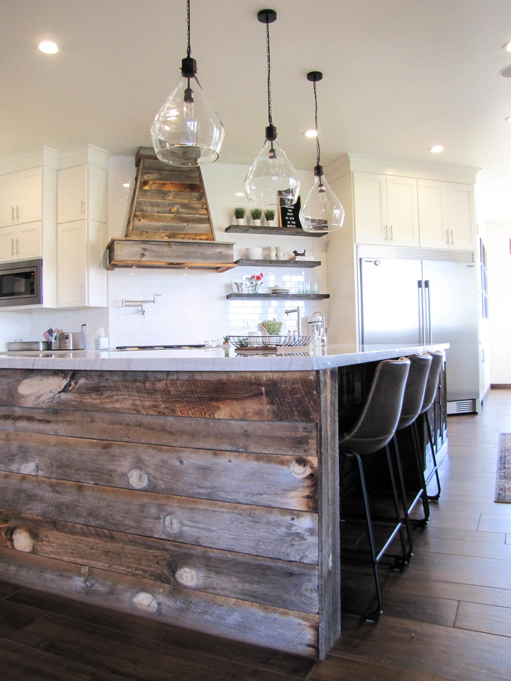 Kitchen - large transitional porcelain tile and brown floor kitchen idea in Phoenix with white cabinets, white backsplash, subway tile backsplash, stainless steel appliances and an island