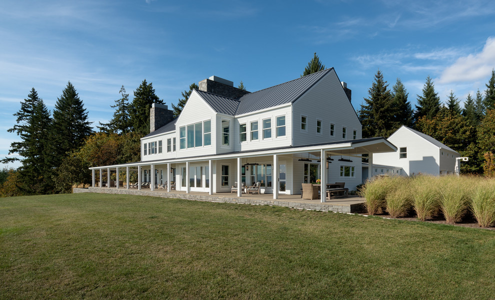 This is an example of an expansive contemporary two-storey white house exterior in Other with concrete fiberboard siding and a tile roof.