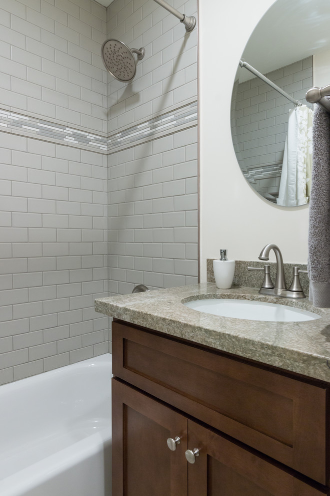Mid-sized transitional bathroom in Los Angeles with shaker cabinets, medium wood cabinets, an alcove tub, a shower/bathtub combo, a two-piece toilet, green tile, ceramic tile, green walls, porcelain floors, an undermount sink, granite benchtops, grey floor and a shower curtain.
