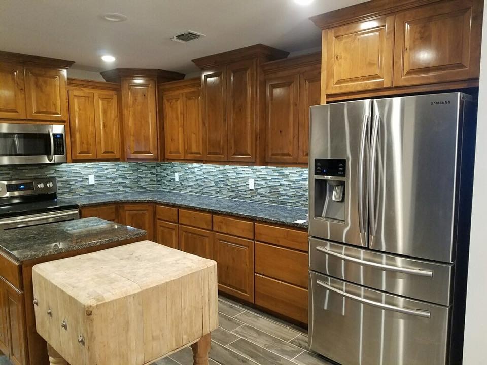 Example of a mid-sized transitional u-shaped porcelain tile and brown floor kitchen design with an undermount sink, raised-panel cabinets, medium tone wood cabinets, granite countertops, multicolored backsplash, matchstick tile backsplash, stainless steel appliances and an island