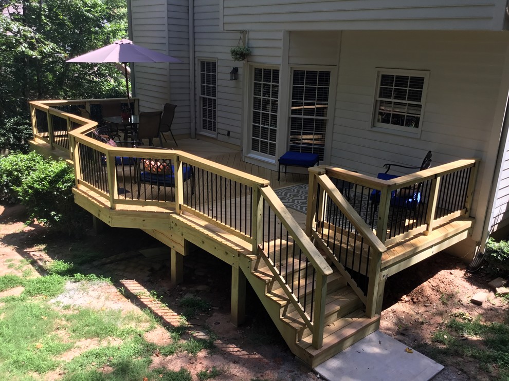 Large contemporary front yard verandah in Atlanta with a container garden, decking and a roof extension.