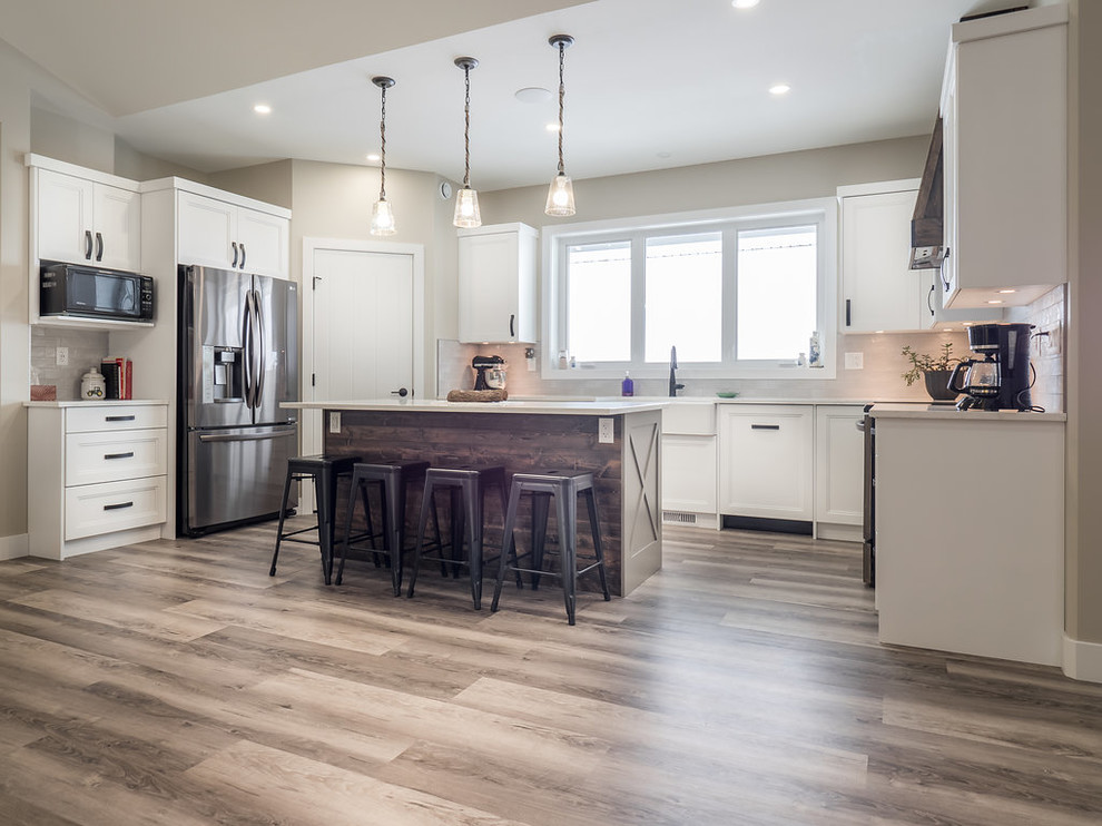 Inspiration for a large transitional u-shaped vinyl floor and multicolored floor eat-in kitchen remodel in Edmonton with a double-bowl sink, recessed-panel cabinets, white cabinets, quartzite countertops, white backsplash, ceramic backsplash, stainless steel appliances and an island