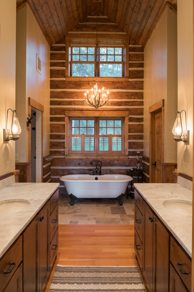 This is an example of a mid-sized country master wet room bathroom in Minneapolis with recessed-panel cabinets, a claw-foot tub, a two-piece toilet, white tile, subway tile, beige walls, an undermount sink, marble benchtops, brown floor, an open shower, medium wood cabinets and medium hardwood floors.
