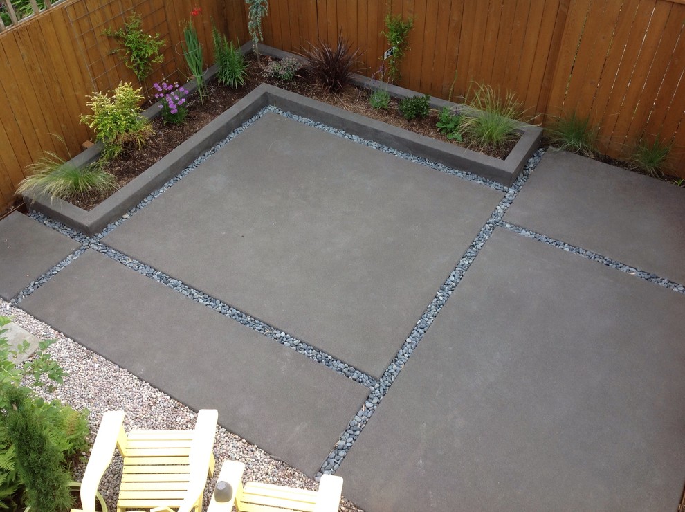Inspiration for a mid-sized modern backyard patio in Portland with a container garden, stamped concrete and no cover.
