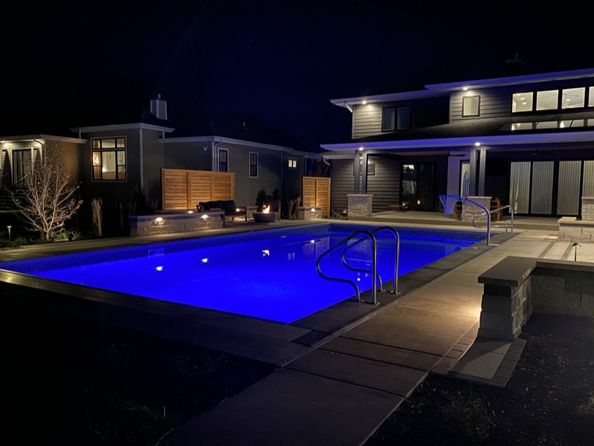 Immagine di una piscina monocorsia minimalista rettangolare di medie dimensioni e dietro casa con paesaggistica bordo piscina e pavimentazioni in pietra naturale