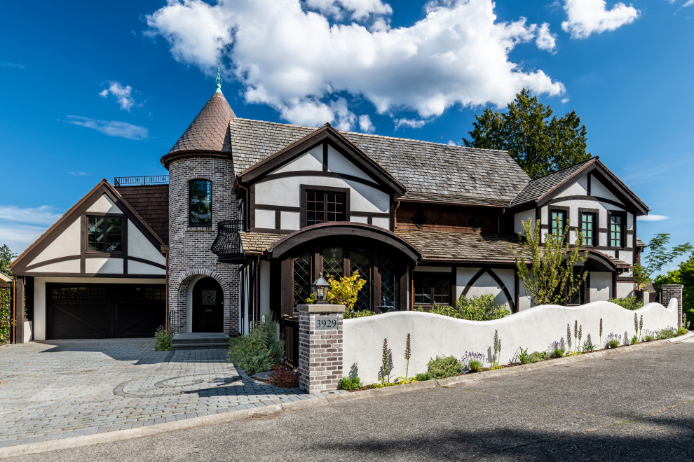 Cette photo montre une façade de maison blanche chic à un étage avec un toit à deux pans, un toit en shingle et un toit marron.