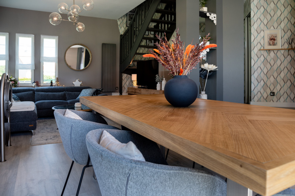Inspiration pour une salle à manger nordique de taille moyenne avec un mur gris, parquet clair, un poêle à bois et un sol gris.