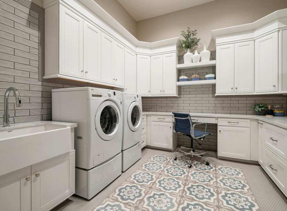 This is an example of a large transitional u-shaped dedicated laundry room in Phoenix with a farmhouse sink, beaded inset cabinets, white cabinets, quartz benchtops, grey splashback, porcelain splashback, grey walls, porcelain floors, a side-by-side washer and dryer, blue floor and white benchtop.
