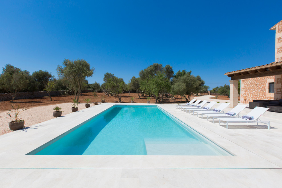 Inspiration for a mid-sized country front yard rectangular lap pool in Palma de Mallorca with a pool house.