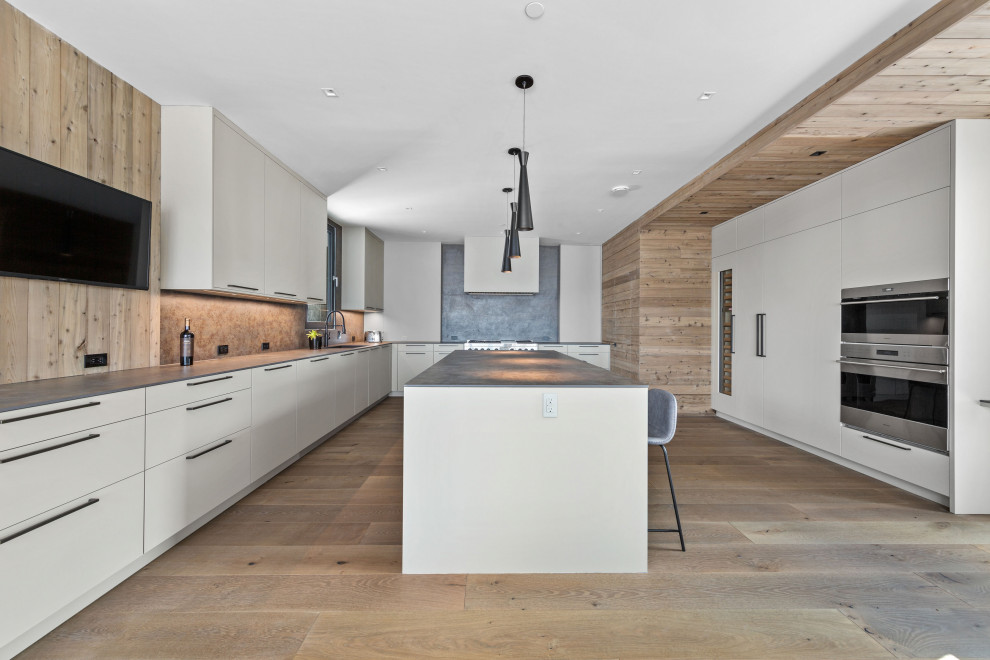 Immagine di una grande cucina minimalista con ante lisce, ante bianche, paraspruzzi grigio e top grigio